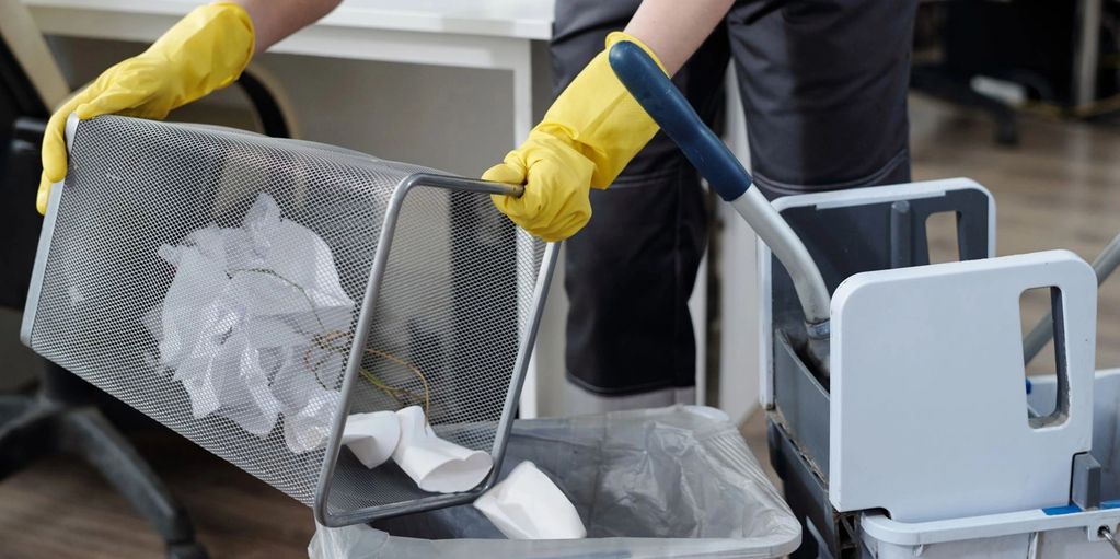 Cleaning professional emptying office bin