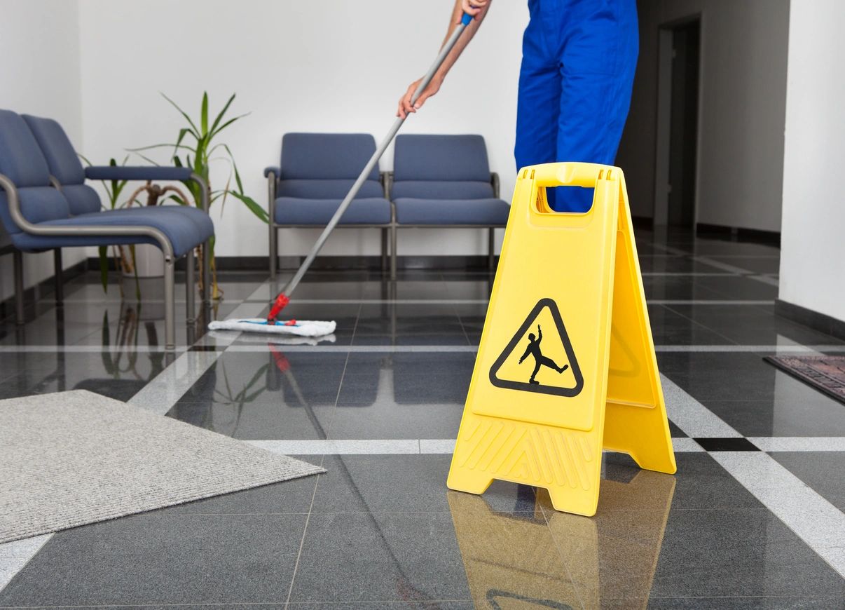 Office floor being mopped with wet floor sign